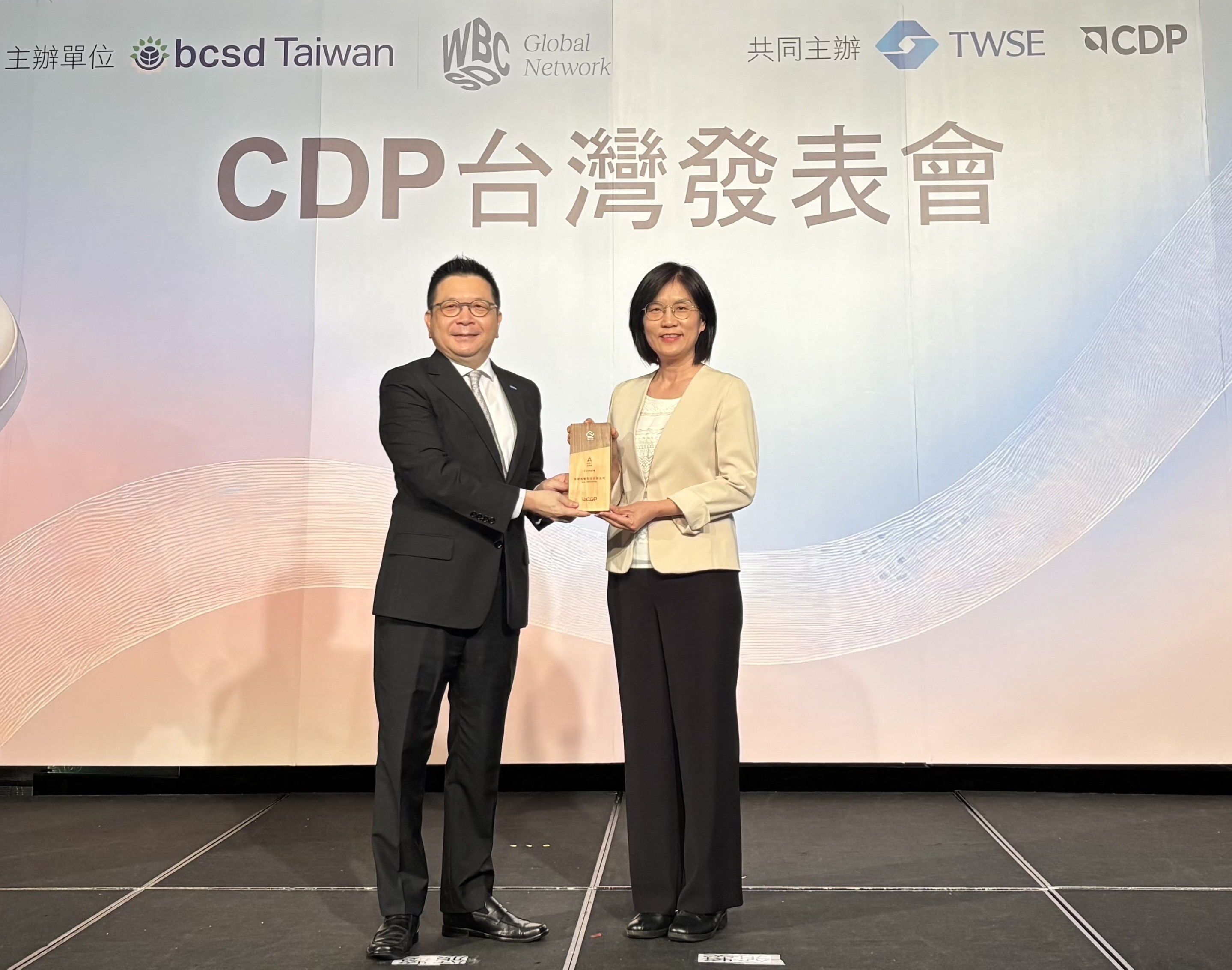 友達永續成果再獲國際評比肯定，獲頒CDP氣候與水資源雙項領導力評級。今由臺灣證券交易所董事長林修銘（左）頒獎，友達光電永續長古秀華（右）代表受獎